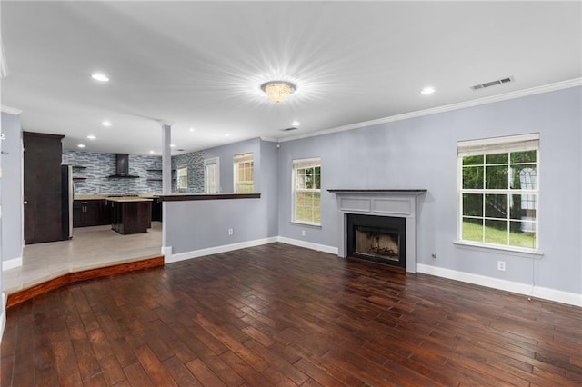 unfurnished living room featuring crown molding and wood-type flooring