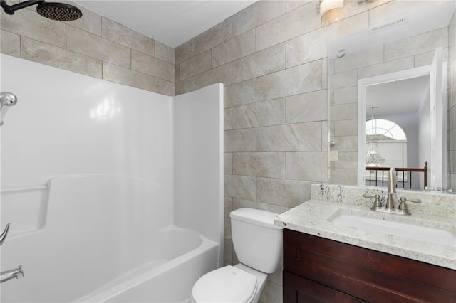 full bathroom with toilet, tile walls, vanity, and shower / bathing tub combination