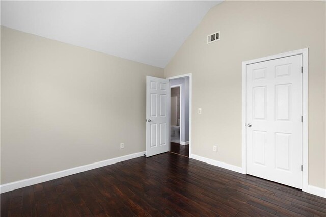 unfurnished bedroom featuring high vaulted ceiling and dark hardwood / wood-style floors