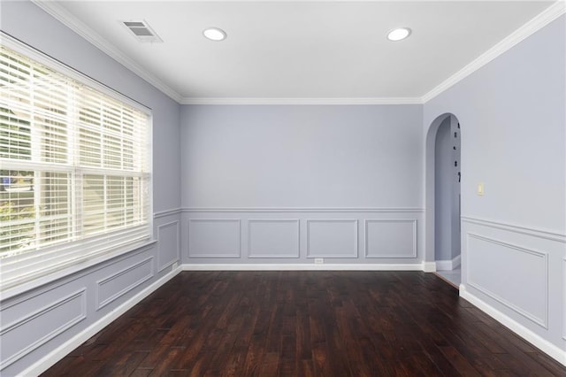 spare room featuring dark wood-type flooring and crown molding