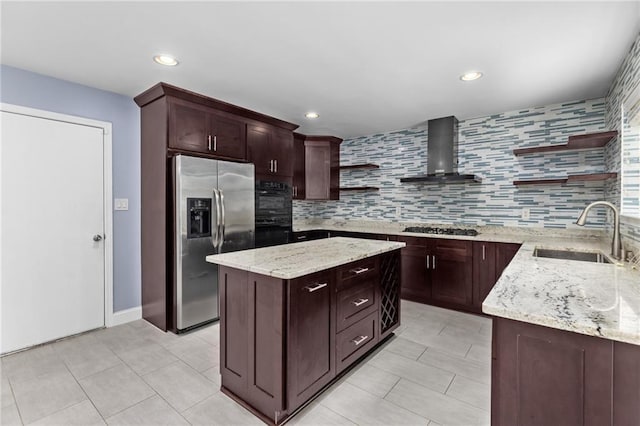 kitchen with appliances with stainless steel finishes, sink, wall chimney exhaust hood, light stone counters, and a center island