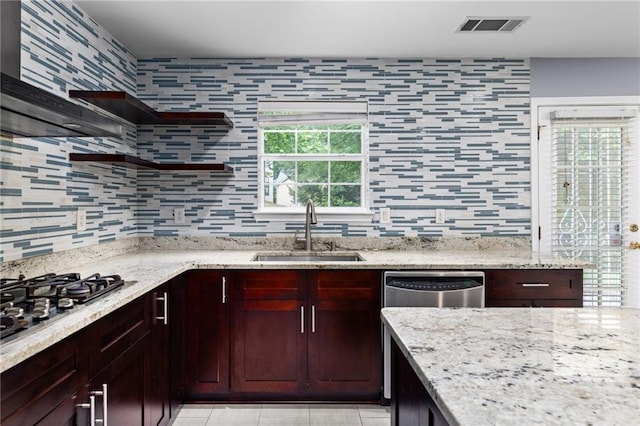 kitchen with stainless steel appliances, light stone counters, tasteful backsplash, and sink