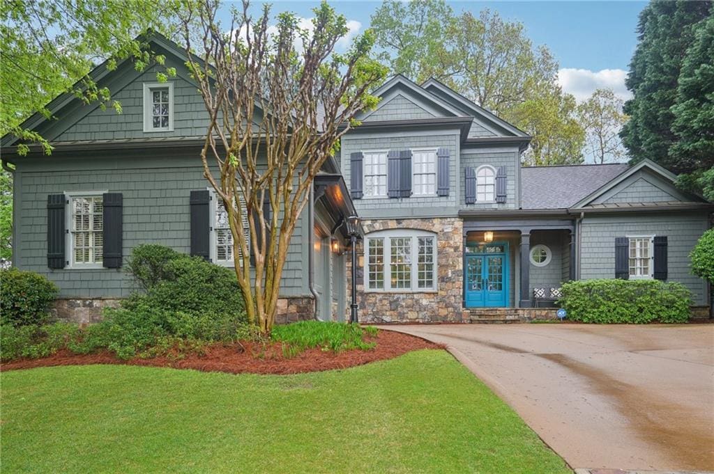 view of front facade featuring a front yard and stone siding