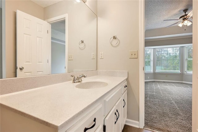 bathroom with vanity, ceiling fan, and a textured ceiling