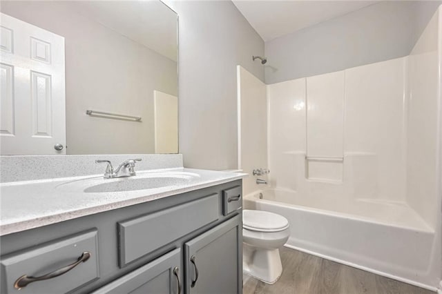 full bathroom with hardwood / wood-style floors, shower / bath combination, vanity, and toilet