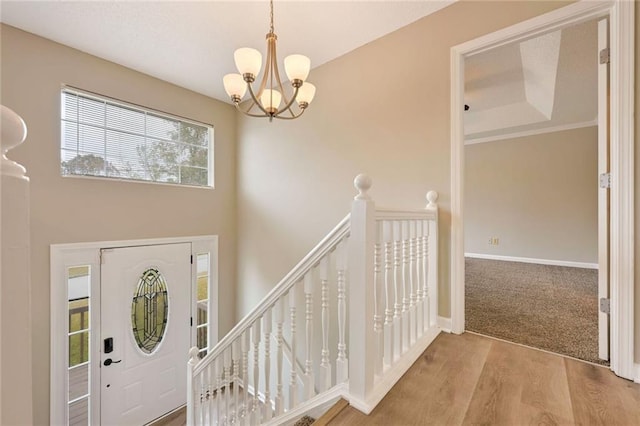 foyer featuring hardwood / wood-style flooring, a chandelier, and a raised ceiling