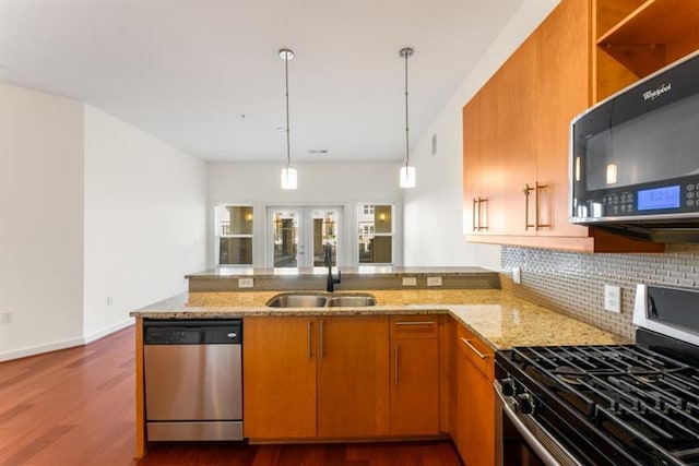 870 Inman Village Pkwy Unit 203, Atlanta, GA 30307 - kitchen with stainless steel appliances, a peninsula, decorative backsplash, brown cabinets, and dark wood-style floors
