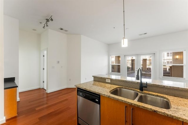 870 Inman Village Pkwy Unit 203, Atlanta, GA 30307 - kitchen featuring dishwasher, wood finished floors, brown cabinets, decorative light fixtures, and light stone counters