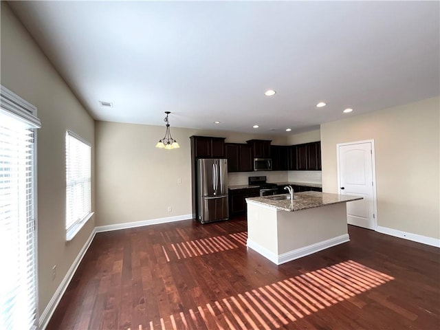 kitchen with appliances with stainless steel finishes, dark wood-style flooring, baseboards, and light stone counters