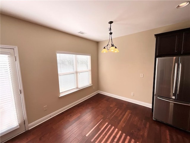 unfurnished dining area featuring dark wood finished floors, visible vents, and baseboards