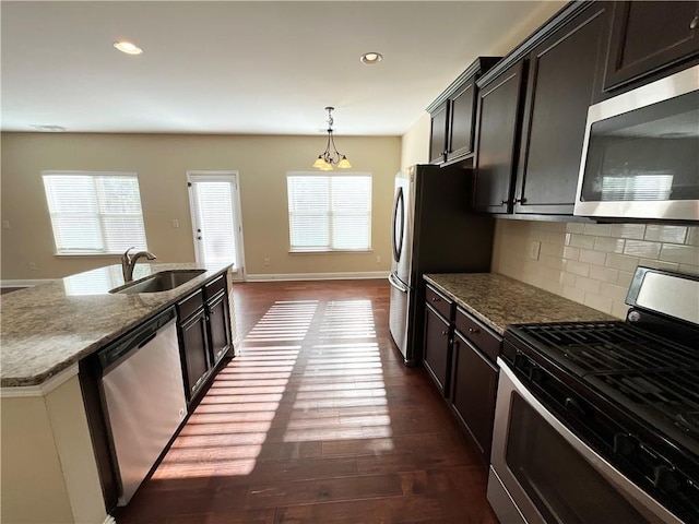 kitchen featuring dark wood-style floors, appliances with stainless steel finishes, backsplash, and a sink