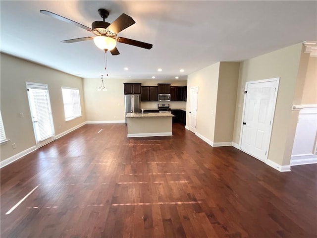 unfurnished living room with ceiling fan, recessed lighting, dark wood finished floors, and baseboards