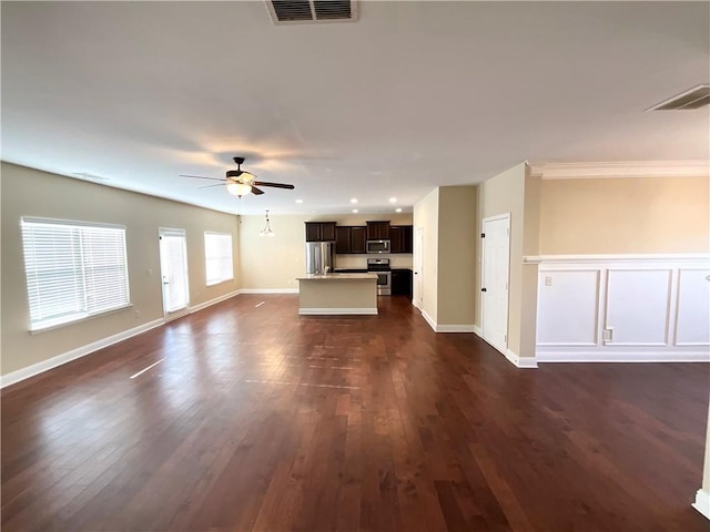 unfurnished living room featuring dark wood-style floors, ceiling fan, visible vents, and baseboards