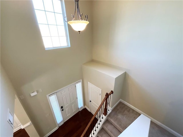 foyer entrance with stairway, a high ceiling, and baseboards