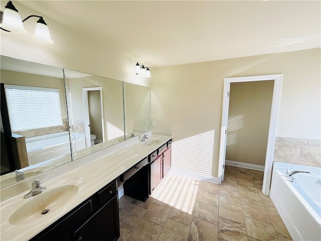 full bath featuring a bath, double vanity, a sink, and toilet