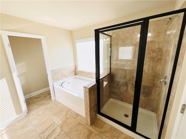 bathroom with a garden tub, baseboards, and a stall shower