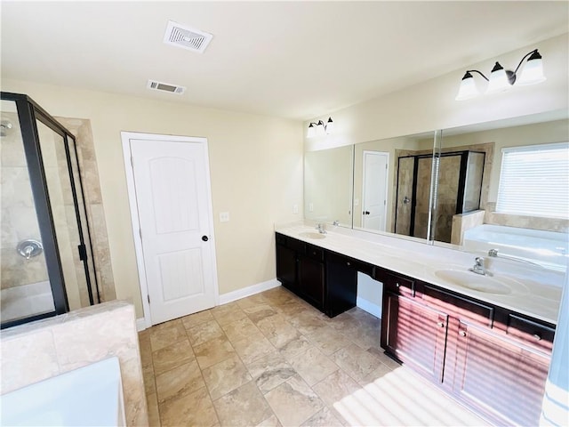 bathroom with a stall shower, visible vents, a sink, and double vanity