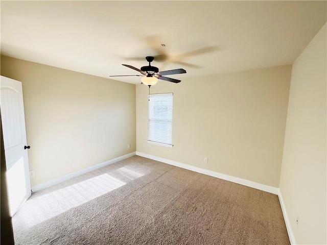 carpeted empty room with baseboards and a ceiling fan