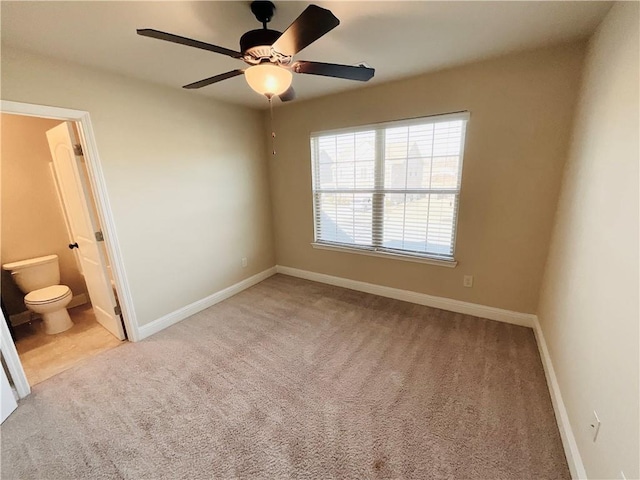 unfurnished bedroom with ceiling fan, carpet, ensuite bath, and baseboards