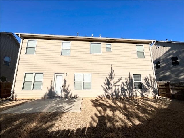 rear view of house featuring fence and a patio