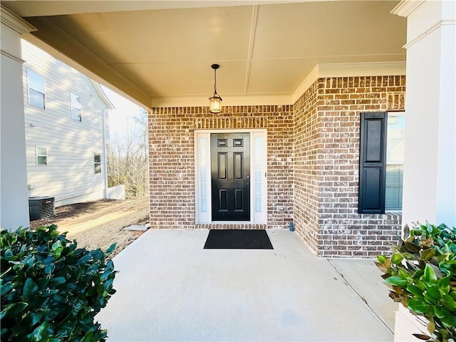 property entrance with cooling unit and brick siding