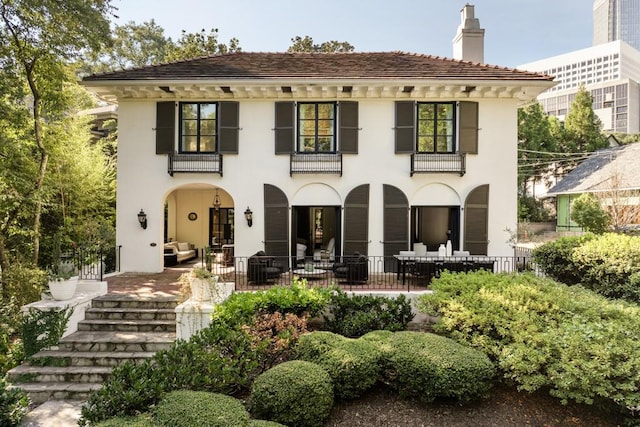 31 Lafayette Dr NE, Atlanta, GA 30309 - back of house featuring a chimney, stucco siding, and a balcony