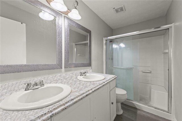 bathroom with toilet, vanity, hardwood / wood-style floors, and walk in shower