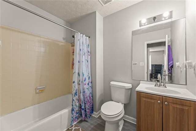 full bathroom featuring shower / bath combo, toilet, a textured ceiling, and vanity