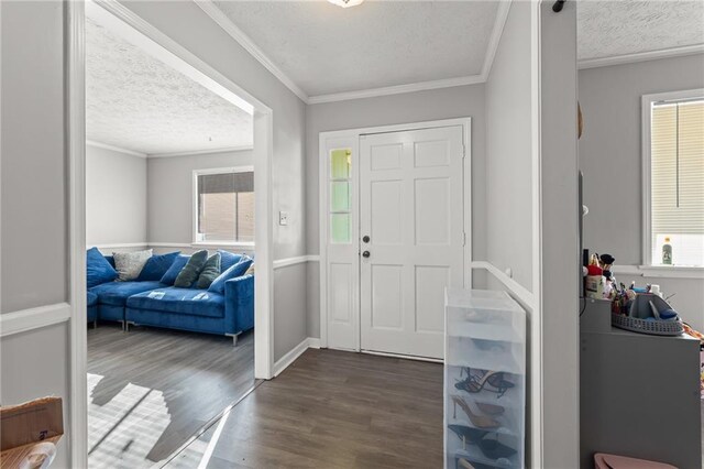 foyer with a textured ceiling, dark hardwood / wood-style flooring, and crown molding