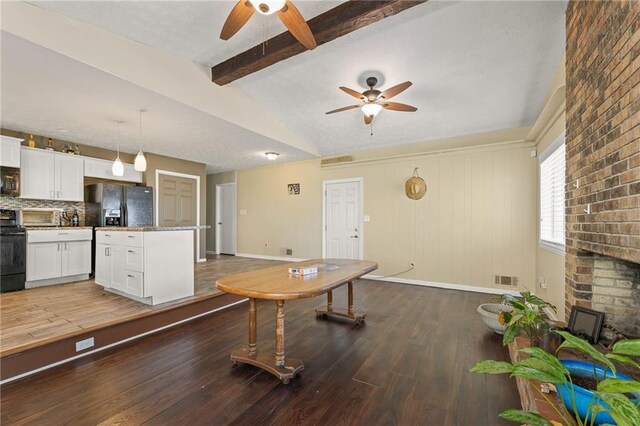 kitchen featuring light stone counters, black appliances, pendant lighting, hardwood / wood-style flooring, and white cabinets