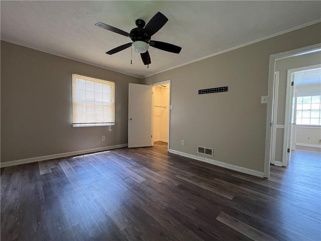 2065 Sandgate Cir, Atlanta, GA 30349 - unfurnished bedroom with dark wood-type flooring, baseboards, ornamental molding, a spacious closet, and ceiling fan