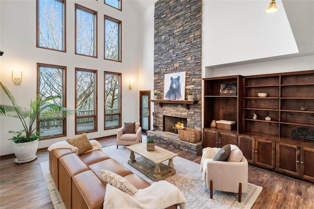 living room featuring a fireplace, hardwood / wood-style floors, and a high ceiling