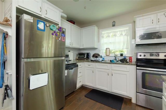 4699 Ballew Dr, Powder Springs, GA 30127 - kitchen featuring stone countertops, wood finish floors, white cabinetry, decorative backsplash, and appliances with stainless steel finishes