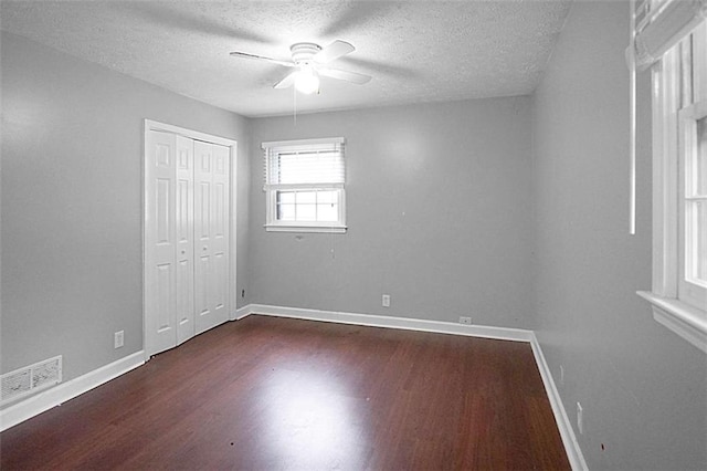 115 Elizabeth Way, Ellenwood, GA 30294 - unfurnished bedroom featuring dark wood-type flooring, a textured ceiling, ceiling fan, and a closet