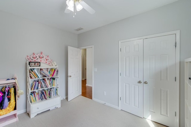 bedroom with light colored carpet, a closet, and ceiling fan