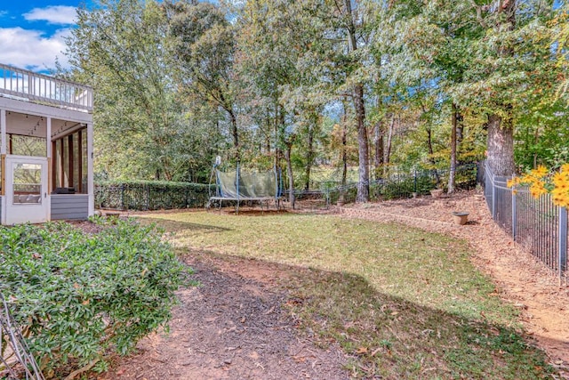 view of yard featuring a sunroom and a trampoline