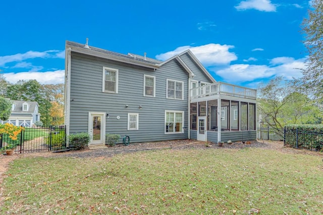 back of house featuring a balcony, a sunroom, and a lawn