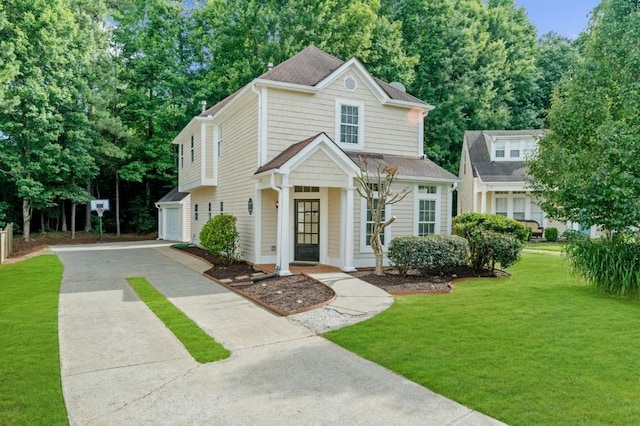 view of property featuring a garage and a front lawn