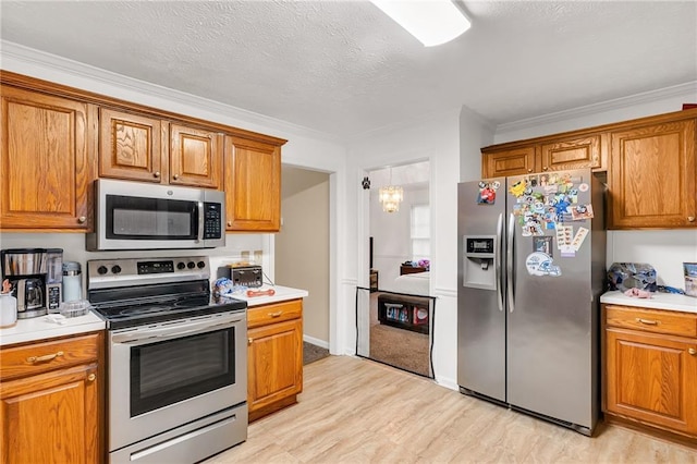 1574 Glenfield Dr, Lawrenceville, GA 30043 - kitchen featuring appliances with stainless steel finishes, brown cabinetry, light wood-type flooring, light countertops, and crown molding