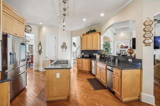 kitchen featuring light wood-type flooring, stainless steel appliances, a sink, and a center island