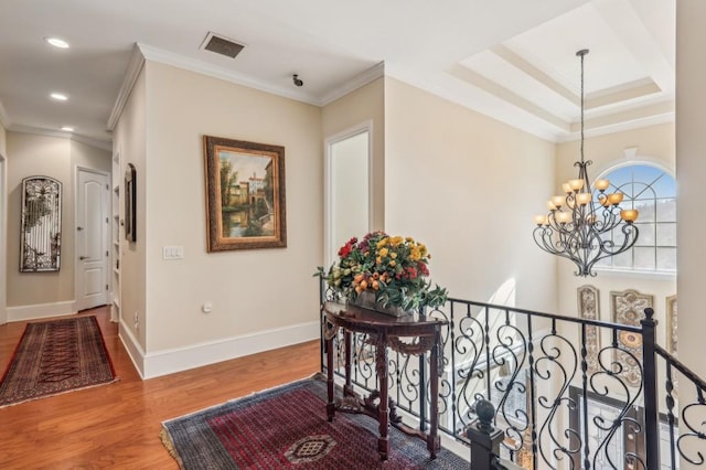 hall featuring visible vents, baseboards, wood finished floors, crown molding, and recessed lighting