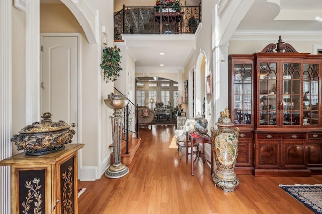 entrance foyer with arched walkways and wood finished floors