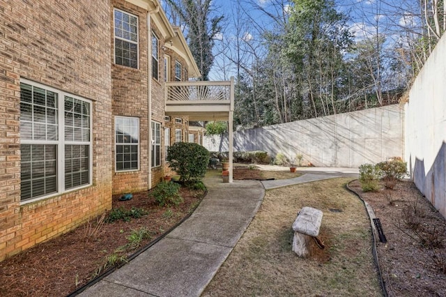 view of yard featuring fence and a balcony