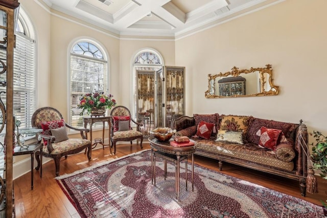 living area featuring visible vents, ornamental molding, wood finished floors, coffered ceiling, and beamed ceiling