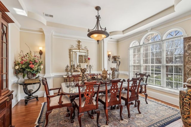 dining room with ornamental molding, visible vents, ornate columns, and wood finished floors