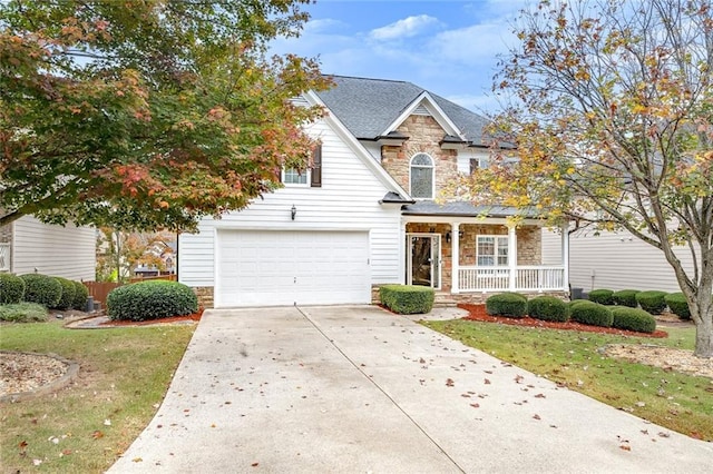 view of front of home with a porch, a front lawn, and a garage