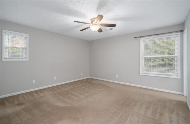 carpeted empty room with a textured ceiling and ceiling fan