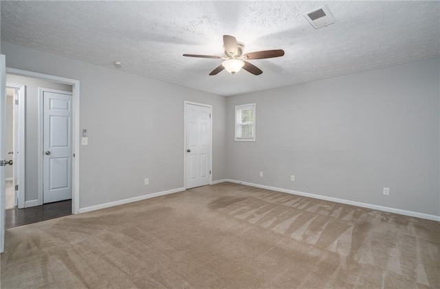 empty room featuring carpet floors, a textured ceiling, and ceiling fan