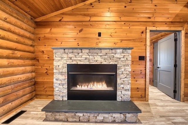 details featuring wood ceiling, a stone fireplace, wood finished floors, and visible vents