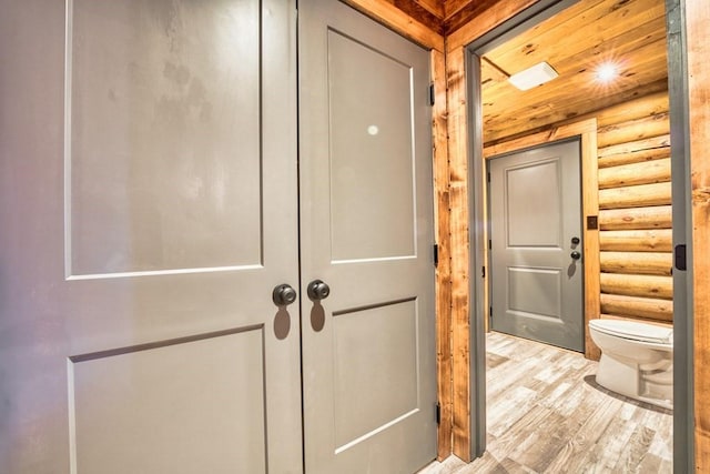 hallway with light wood-style flooring and log walls